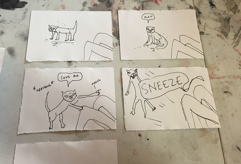 A photo of some comic panels on separate pieces of paper, layed out in order